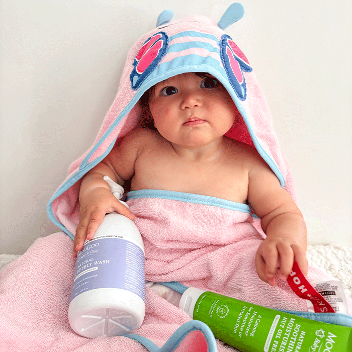 baby holding Moogoo natural 2 in 1 bubbly wash, soap & SLS free, cleanser & bubble bath.