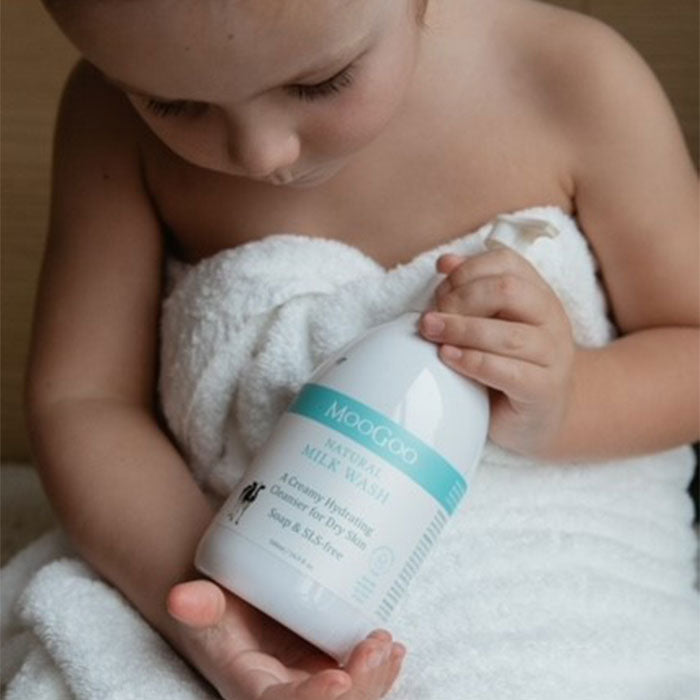 MooGoo Natural Milk Wash with baby wrapped in towel, low irritant natural body cleanser for gentle skin care