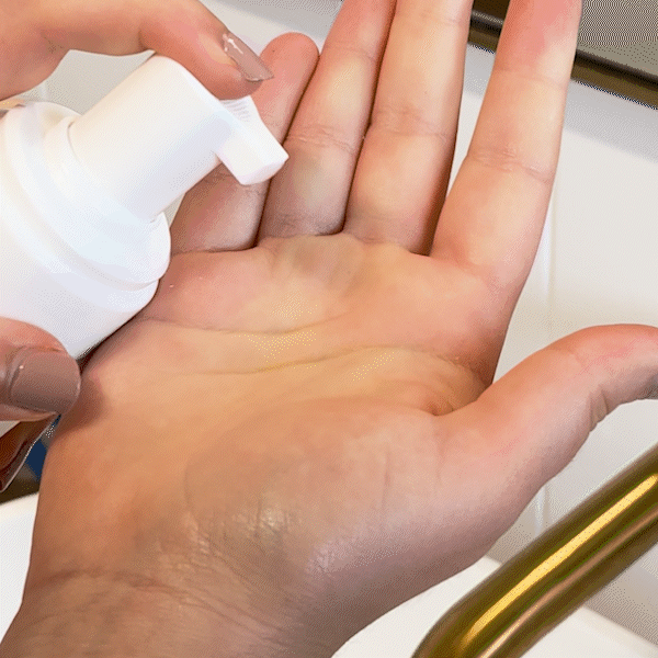 Woman applying MooGoo Gentle Foaming Face Cleanser to face, natural non-clogging SLS-free cleanser to combat congestion and breakouts, clarify and soothe skin.