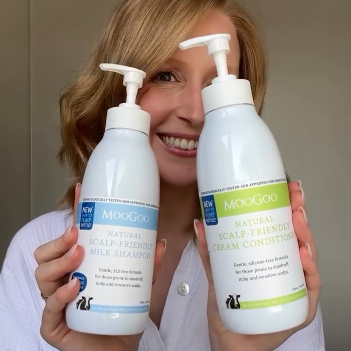 MooGoo Natural Scalp-Friendly Shampoo and Conditioner pack held by woman, gentle hydrating haircare for dandruff prone and sensitive scalp relief