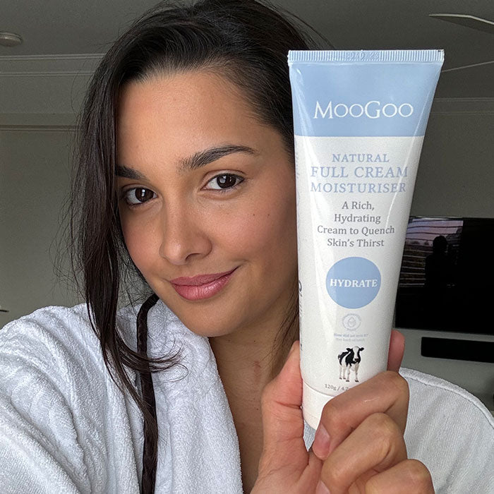 Close-up of MooGoo Full Cream Moisturiser tube in hand, nourishing face and body cream for all skin types and ages