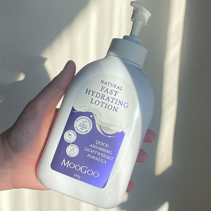 Hand holding MooGoo Quick Absorb Lotion 500g, fast absorbing daily moisturiser with aloe vera and chamomile for delicate and damaged skin