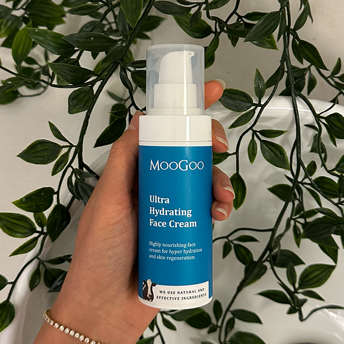 MooGoo Ultra Hydrating Face Cream held in hand with leafy background, natural moisturiser with ceramides and niacinamide for hydration and skin repair