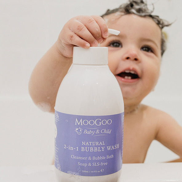 baby holding Moogoo natural 2 in 1 bubbly wash, soap & SLS free, cleanser & bubble bath.