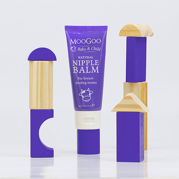 MooGoo Natural Nipple Balm tube displayed among toy blocks, lanolin-free balm made with shea butter and vitamin E to support breastfeeding mums skin.