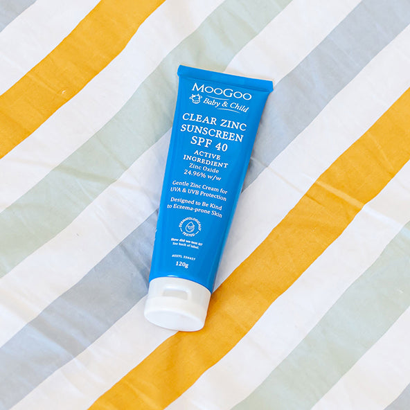 MooGoo Clear Zinc Sunscreen SPF 40 120g on a beach towel, a gentle zinc cream for UVA and UVB protection, kind to eczema prone skin.