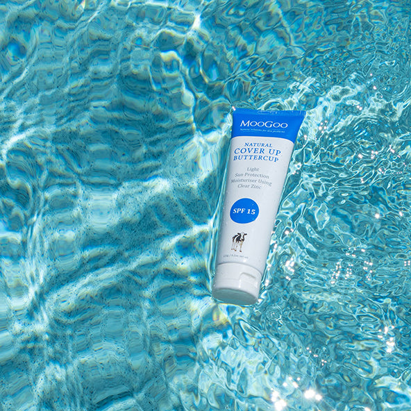 MooGoo Cover Up Buttercup SPF 15 floating in bright pool water, non greasy sunscreen moisturiser with zinc for natural daily sun care