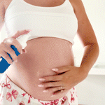 Female applying MooGoo Skin Hero Body Oil to pregnancy bump and rubbing in. With 6 hero nourishing oils to instantly replenish, soften and hydrate dry skin. Lightweight, Fast-Absorbing & Ideal for Pregnancy & Postpartum Skincare