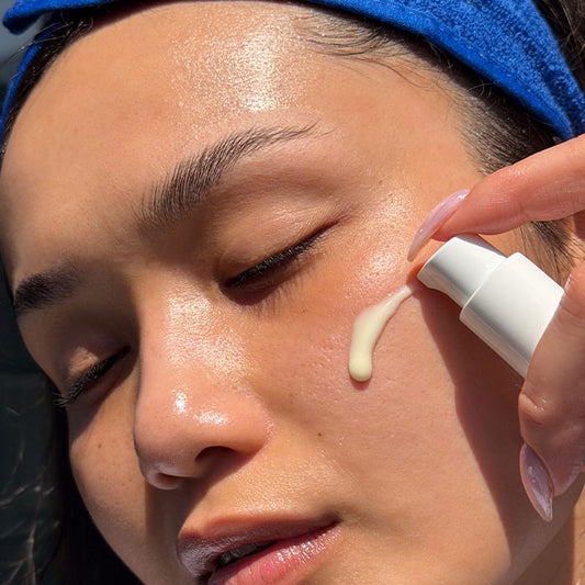 Female applying MooGoo Slow Release Gentle Retinol to their face with a blue terry towelling headband.