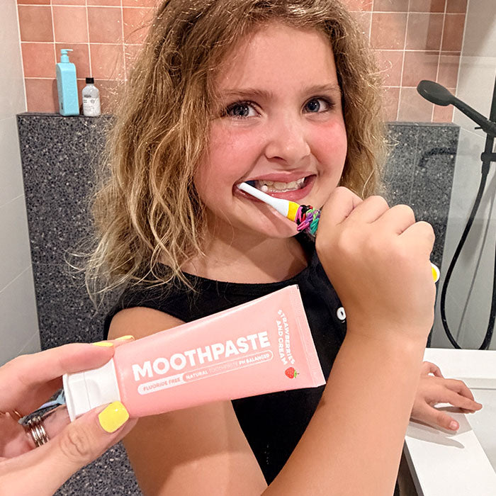 Young girl brushing her teeth with the MooGoo Kids Moothpaste Fluoride Free - Strawberries & Cream.
