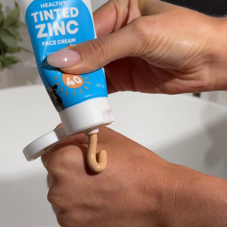 MooGoo Tinted Face Cream with SPF 40 being squeezed out of tube onto persons hand