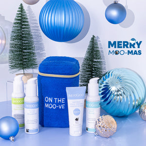MooGoo Travel Pack on Christmas-themed background, including blue terry towelling bag, travel-sized Milk Shampoo, Cream Conditioner, Milk Wash and Full Cream Moisturiser - ideal for sensitive skin, hydration and scalp health