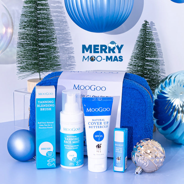 MooGoo Summer Glow Pack with blue bag on Christmas-themed background, includes tanning face mist for bronzed glow, SPF moisturiser and SPF 15 lip balm.