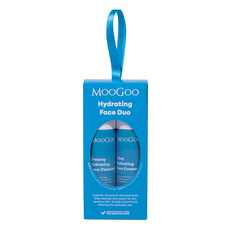 MooGoo Hydrating Face Duo gift set in a bright blue hanging box with one mini creamy hydrating face cleanser and one ultra hydrating face cream, visible through a circular window, on a plain white background.