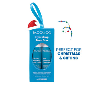 MooGoo Hydrating Face Duo gift set in a bright blue Christmas-themed box with a hanging ribbon, shown on a white background with promotional text and a Santa hat decoration.