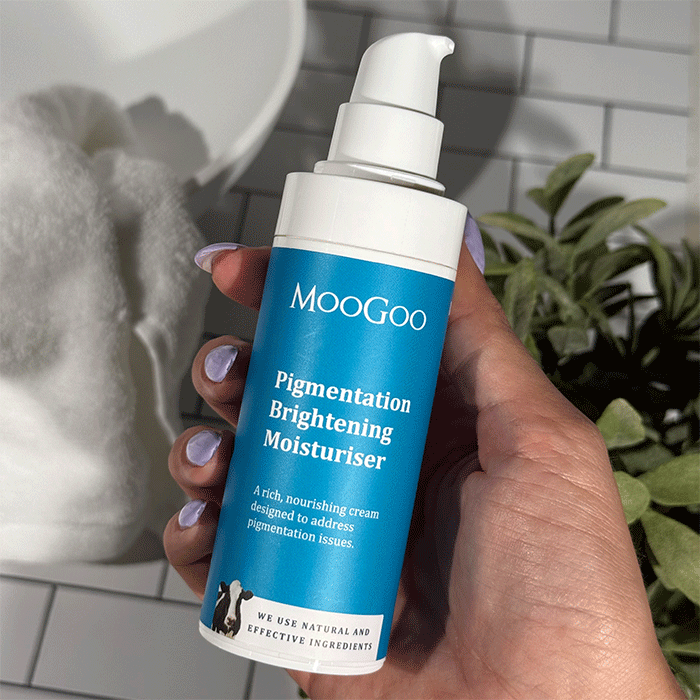 Holding MooGoo Pigmentation Brightening Moisturiser in the bathroom
