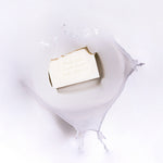 MooGoo Soothing Cleansing Bar Goat’s Milk in splash background, soothing goat’s milk bar with nourishing oils for sensitive or eczema-prone skin.